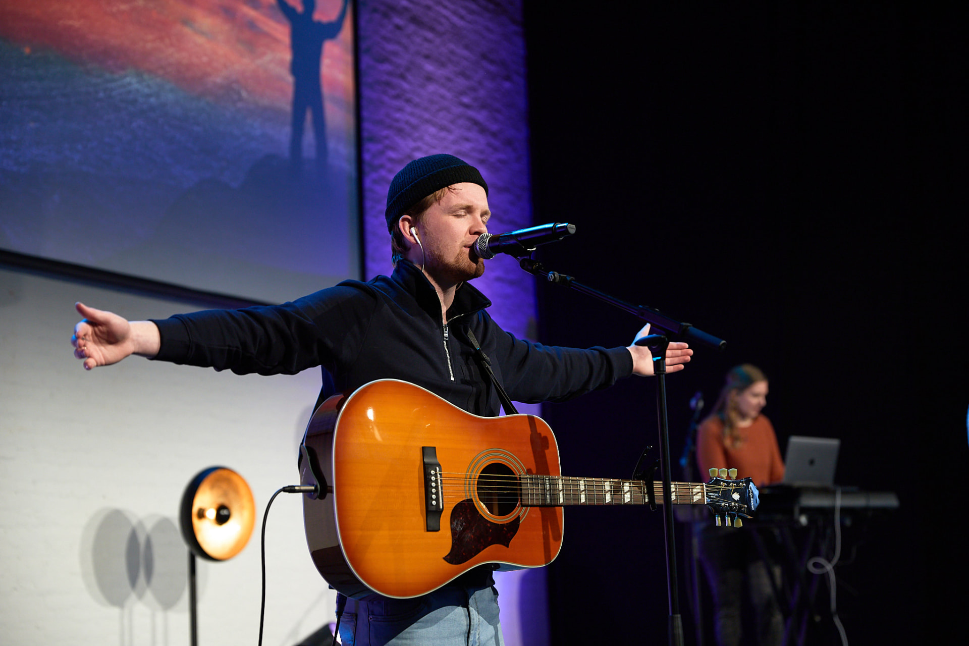 Worshipleider met gitaar tijdens de dienst